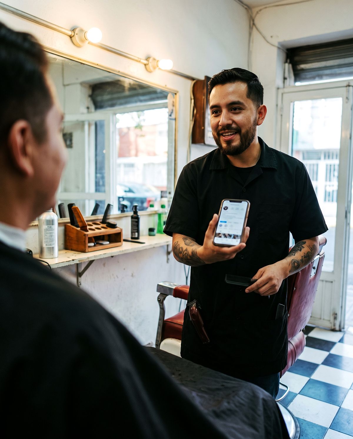 Barbero mostrando su página en el celular
